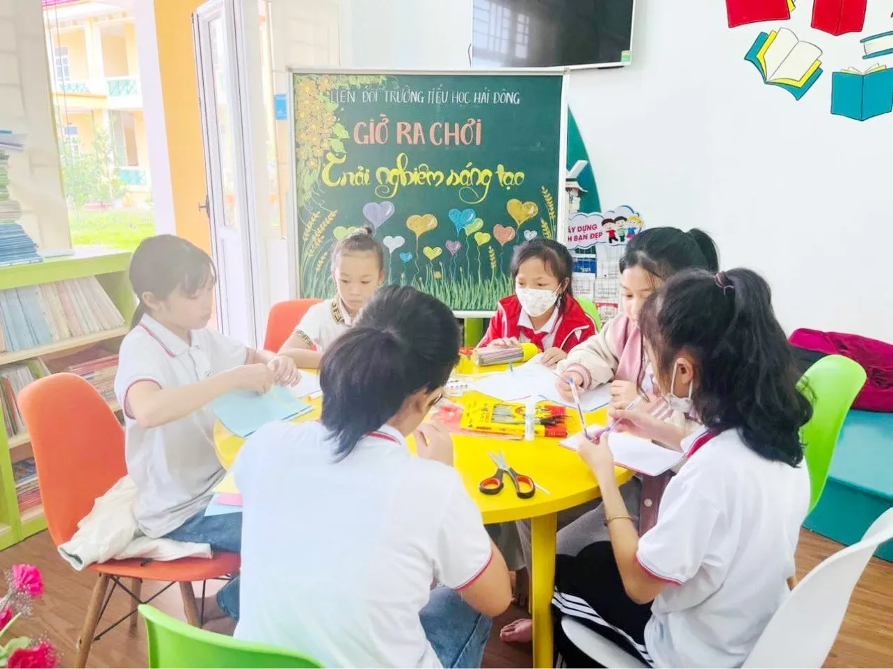 Nhóm học sinh cùng nhau trao đổi và trang trí các sản phẩm bìa sách sáng tạo