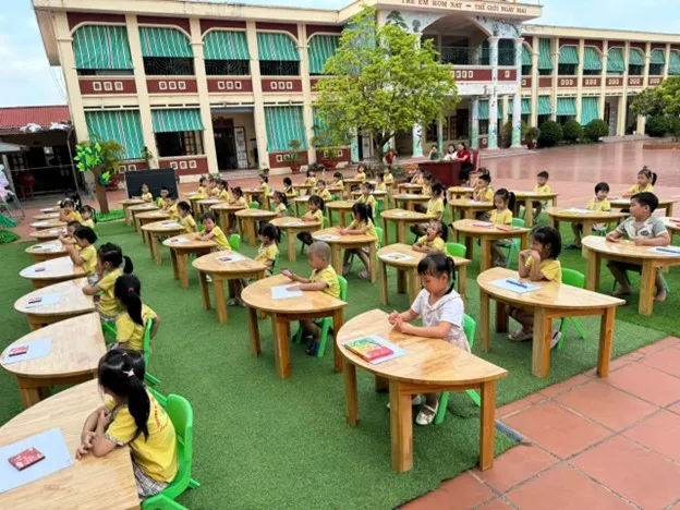 Bé tập trung thể hiện tài năng qua bức tranh vẽ chủ đề trường mầm non hạnh phúc