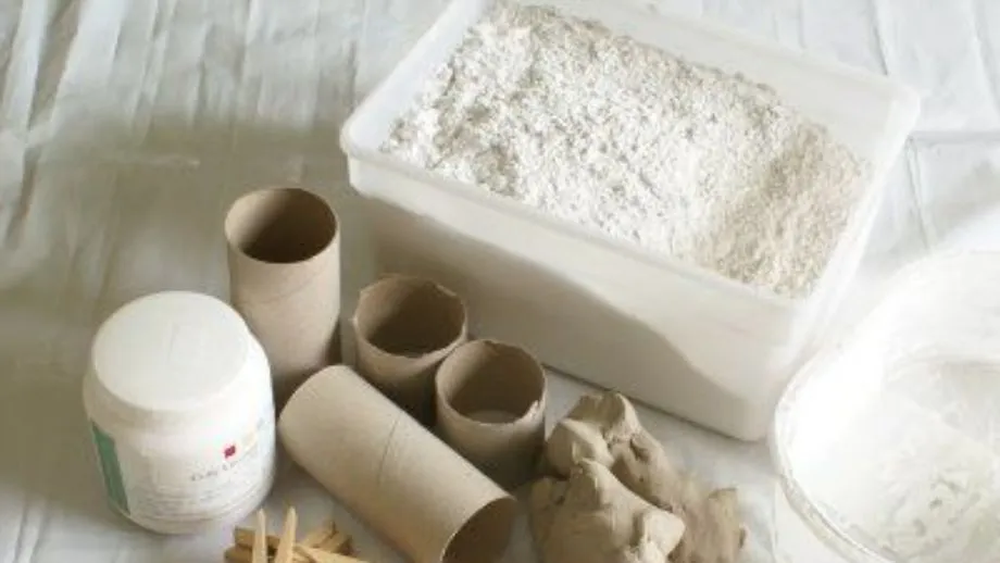 Bàn làm việc với thùng trộn thạch cao, cân điện tử, cốc đong và các dụng cụ khuấy