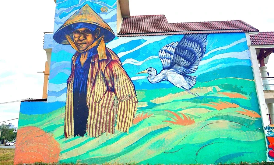 Các họa sĩ đang hoàn thiện tác phẩm tranh vẽ trên tường đầy màu sắc