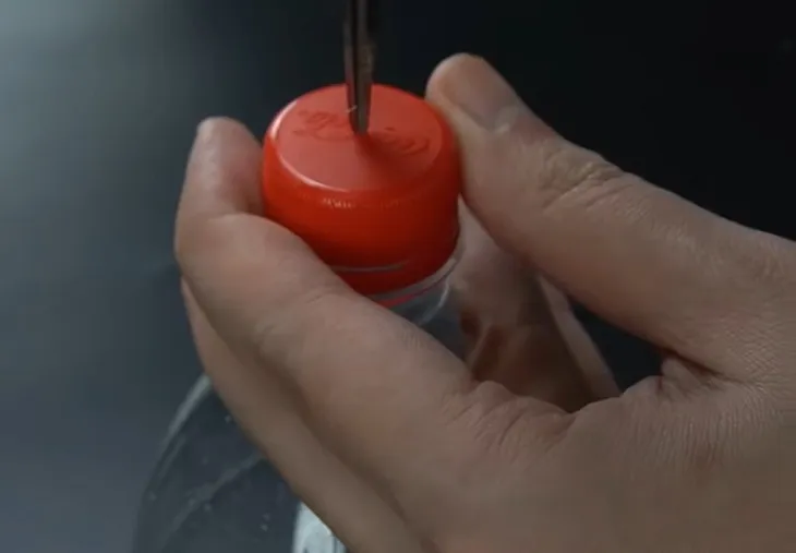 Đục lỗ trên nắp chai.