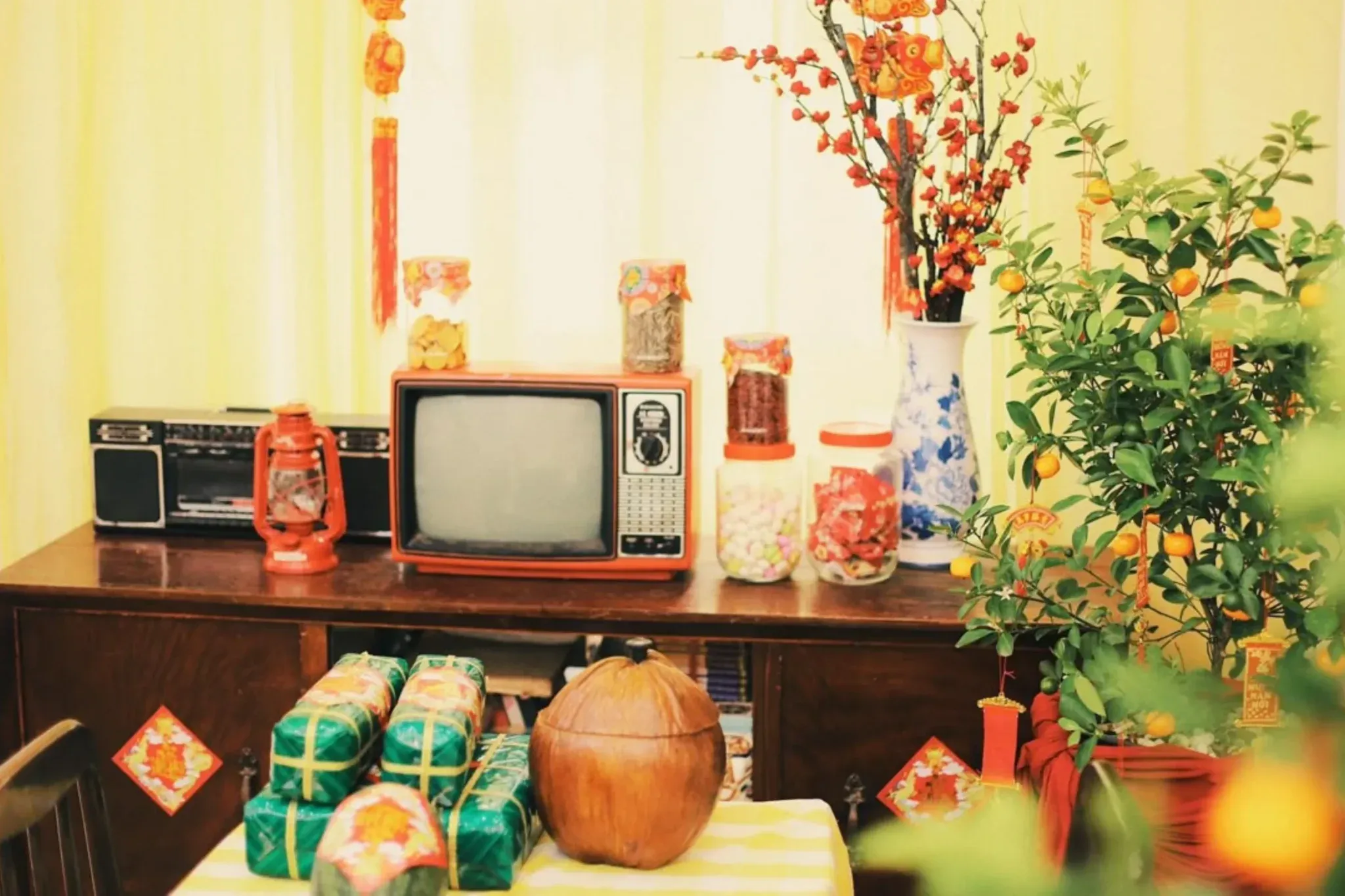 Không gian decor tết phong cách Vintage với tivi cổ và hoa mai đào.