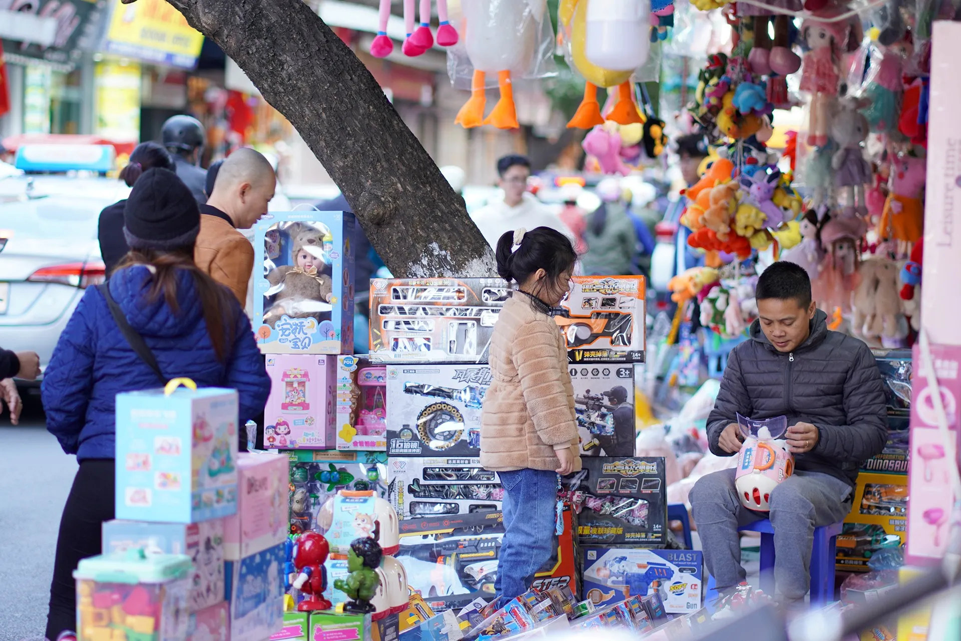 Gia đình nhỏ trên đường đi chơi Tết tranh thủ ghé phố đồ chơi chọn quà cho con