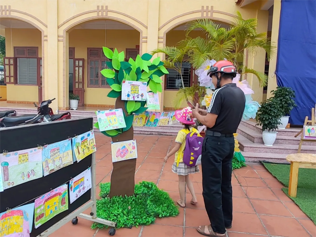 Phụ huynh hào hứng tham quan khu trưng bày tranh vẽ chủ đề trường mầm non của con em