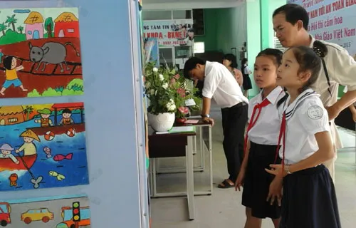 Phụ huynh và học sinh tham quan các bức tranh vẽ an toàn giao thông của họa sĩ tại triển lãm