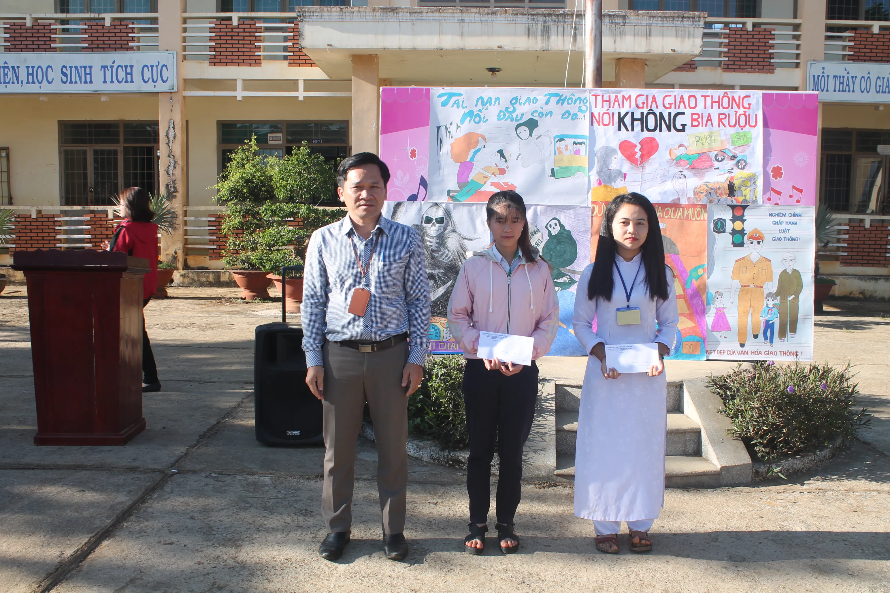 Thầy Hiệu trưởng trao giải Nhất cho các em có bài vẽ tranh tuyên truyền an toàn giao thông ấn tượng