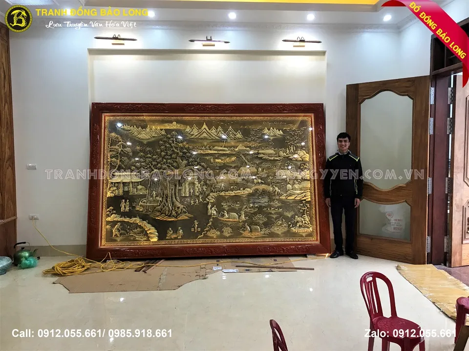 Bức tranh phong cảnh quê hương với người nông dân đang cày ruộng, cánh đồng lúa xanh mướt và dãy núi phía xa